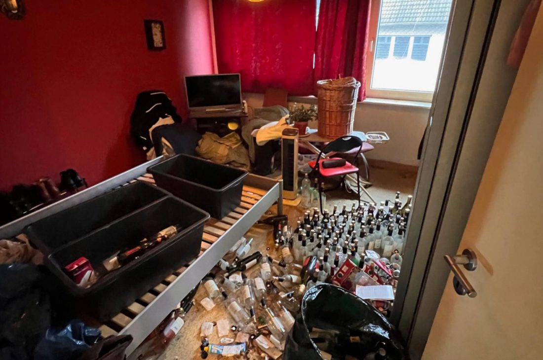 Mit Flaschen und Hausrat zugestelltes Schlafzimmer vor der Messie-Entrümpelung