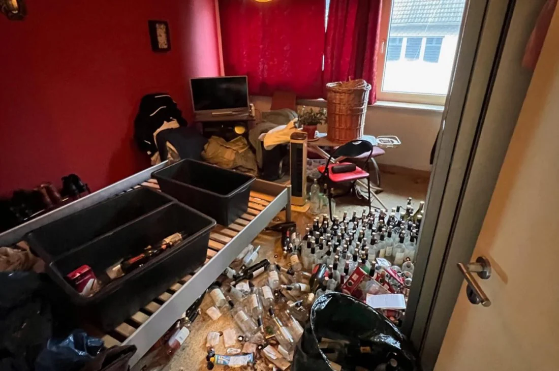 Mit Flaschen und Hausrat zugestelltes Schlafzimmer vor der Messie-Entrümpelung